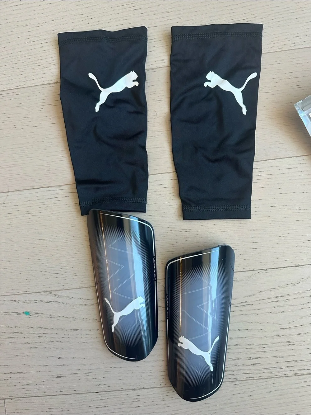 Puma Black Shin Guards with White Logos and Black Sleeves
